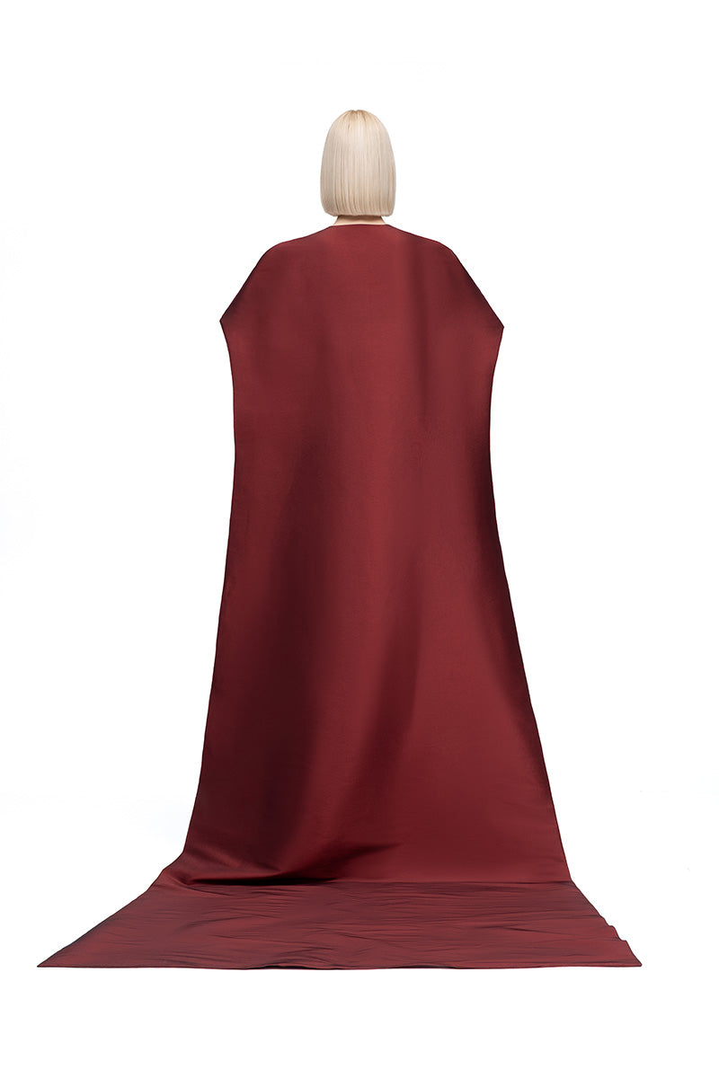 Moon Hakaan Yildirim Lily Cape in wine, stylish jacket with flowing fabric and elegant design, displayed on a hanger.