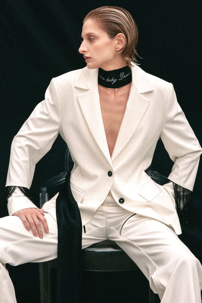 White blazer with beaded fringe by Vaska, featuring a tailored fit and decorative beaded fringe details on the sleeves and hem.