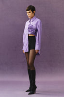 Sayya violet shirt with a floral pattern, long sleeves and a relaxed fit, displayed on a hanger.