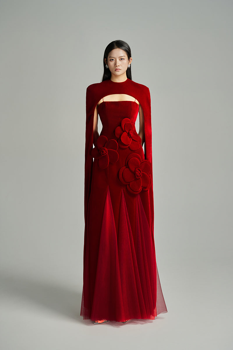 Red velvet Preston Cape gown by Happy Clothing, featuring floral petal design and elegant drape for a stylish look.