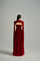 Red velvet Preston cape gown by Happy Clothing from the CULT MIA X collection, featuring elegant petal design and flowing fabric.
