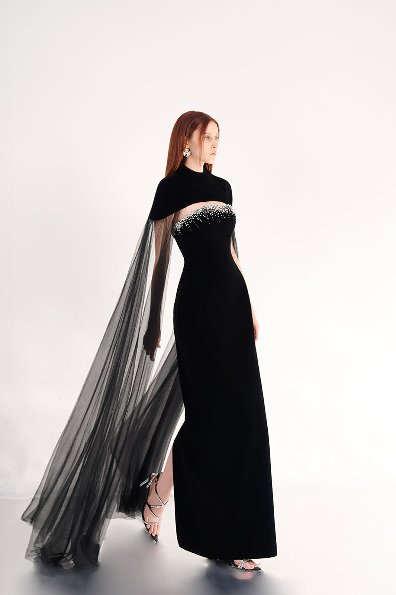 Black velvet gown with cape details by Happy Clothing, featuring elegant flowing fabric and intricate cape design.