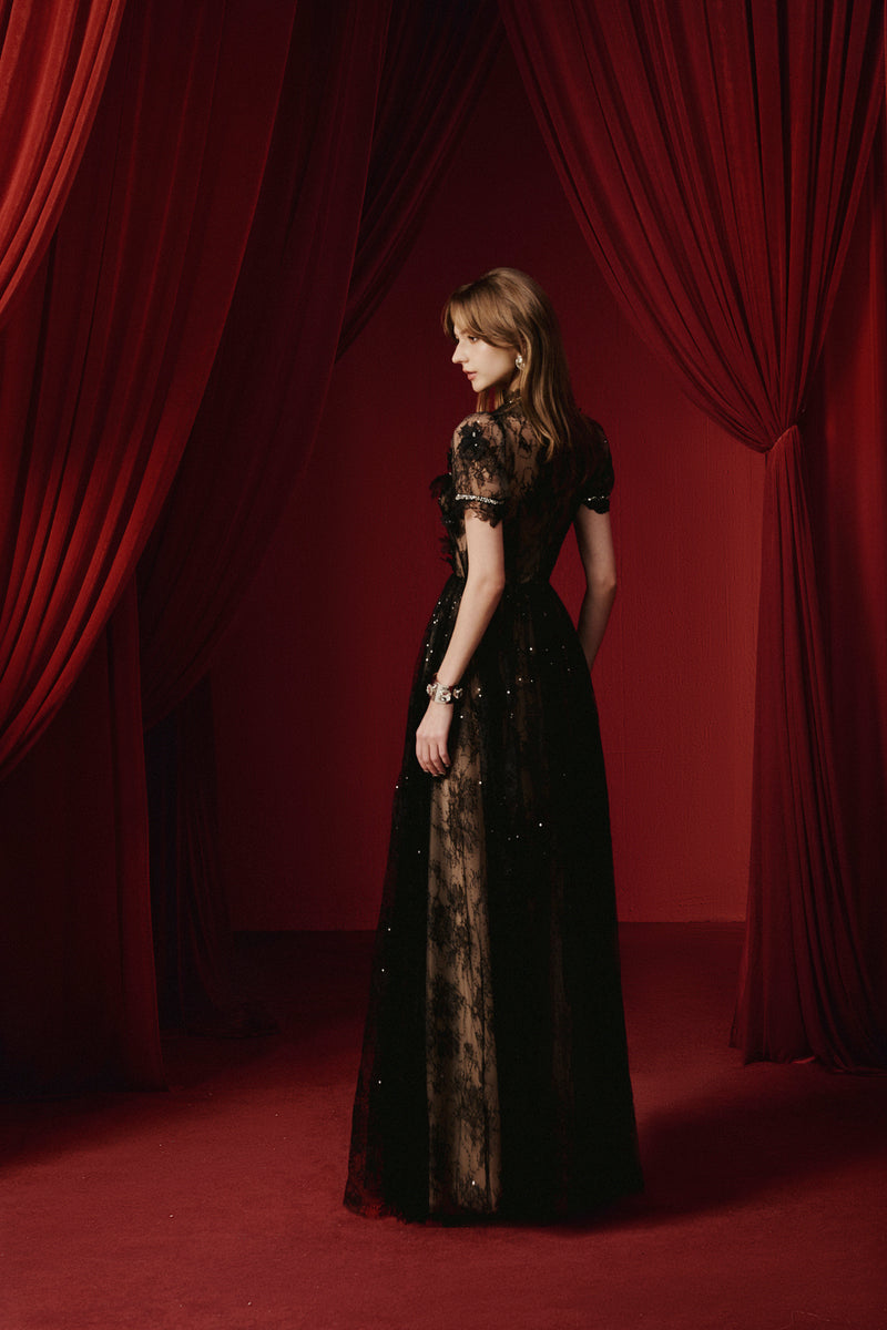 Black YEDDA gown by JOSÉPHINE, elegant floor-length dress with a flowing silhouette and detailed neckline.