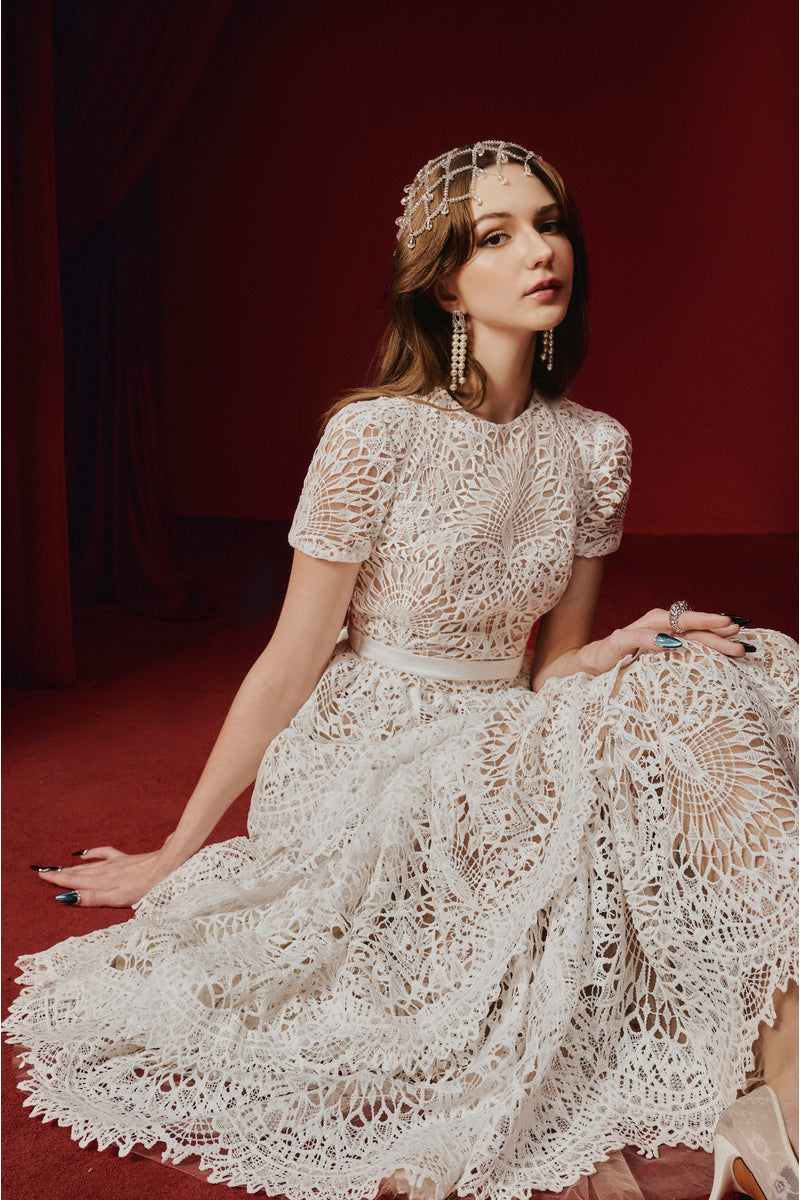 White Rella gown by Joséphine, elegant floor-length dress with flowing fabric and intricate detailing, perfect for formal occasions.