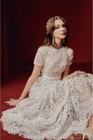 White Rella gown by Joséphine, elegant floor-length dress with flowing fabric and intricate detailing, perfect for formal occasions.