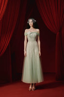 Elegant green TINLEY gown by JOSÉPHINE, flowing fabric with intricate detailing, perfect for formal occasions.