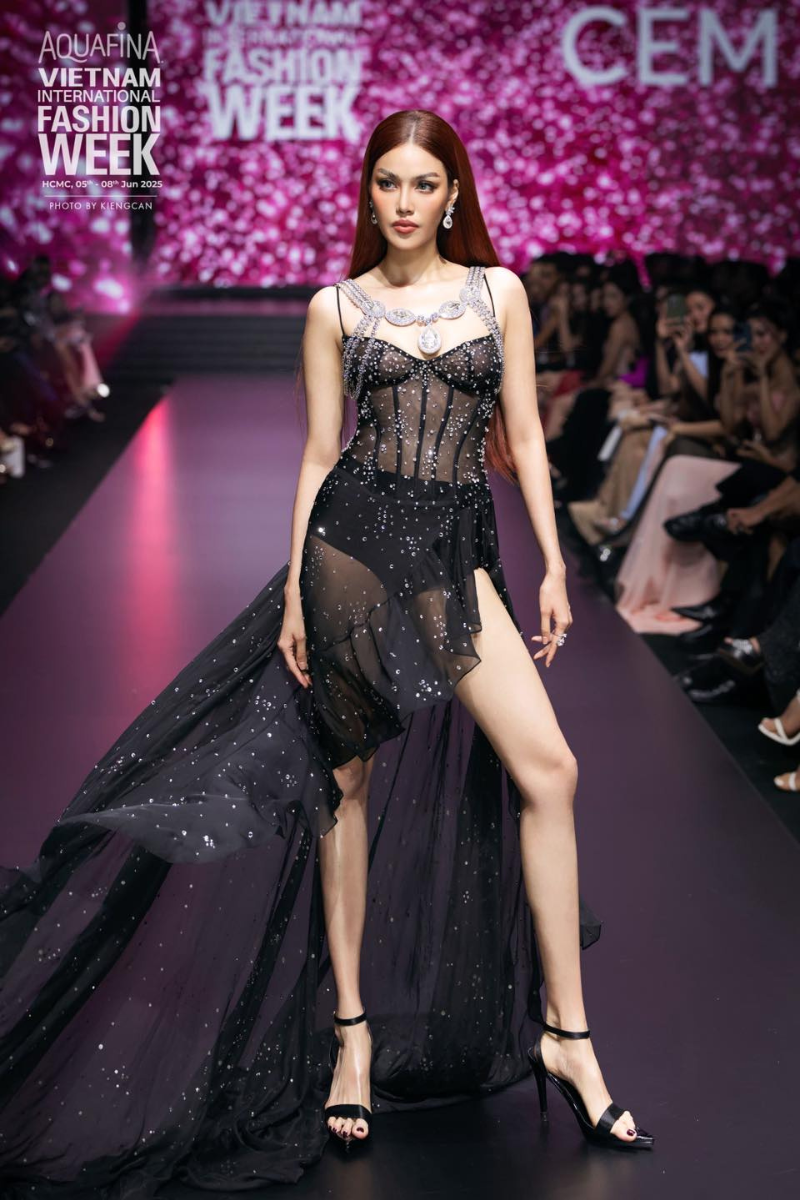 Black Starburst high-low gown by CEM, elegant evening dress with a flowing design and starburst pattern, shown on a model.