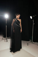Black one-shoulder maxi gown with a slit from Happy Clothing, elegant and flowing, suitable for formal occasions.