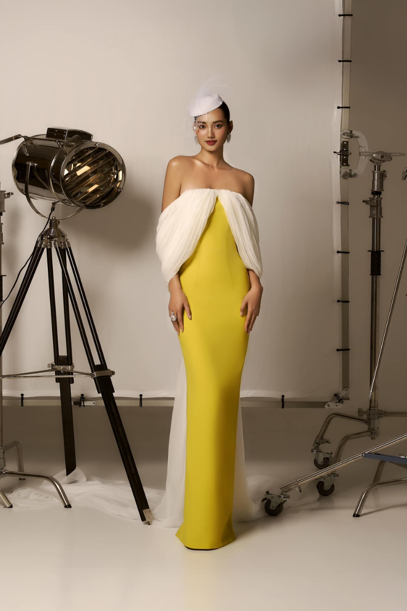 Yellow and white off-shoulder gown by CEM, flowing train with elegant design, perfect for formal occasions.