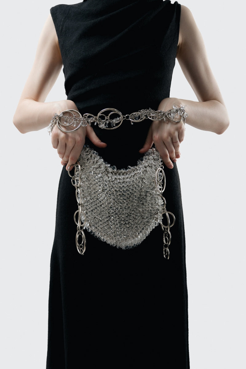 Millanne Tale glass shoulder bag with clear, sleek design and silver-tone hardware, carried on a model's shoulder.