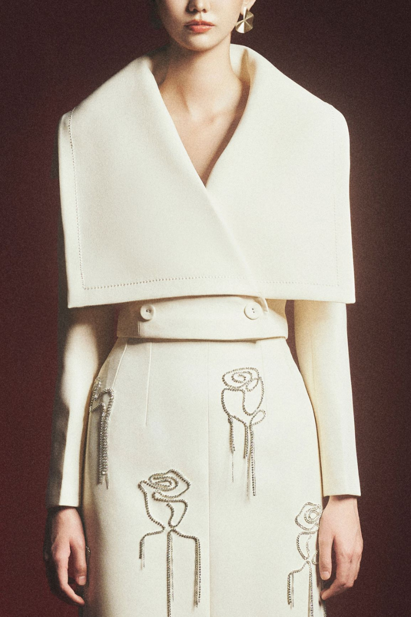 Maison Des Copains Grayson sheath floral midi skirt displayed on a hanger, showcasing its elegant design and floral pattern.