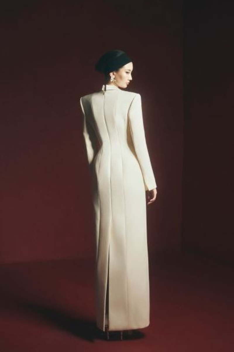 Maison Des Copains Miranda sheath gown with peak lapel, floor-length design, elegant black fabric, displayed on a dress form.