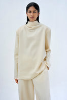 Light blue URA ELI TOP, casual women's top with a relaxed fit, shown on a hanger against a neutral background.