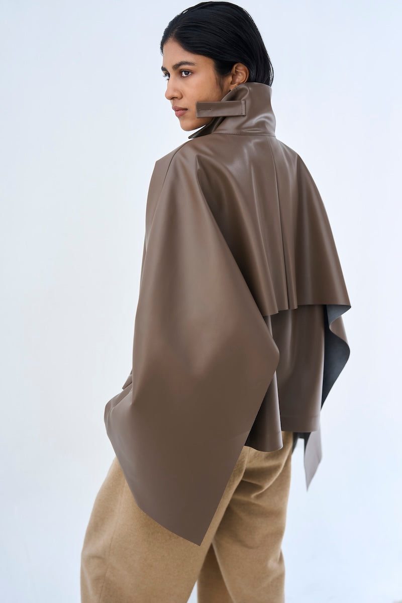 Ura PIA trench jacket in neutral color, tailored fit with classic design, displayed on a hanger.