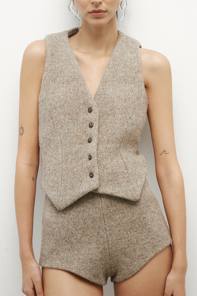 JC Pajares virgin wool culotte shorts in neutral fabric, featuring a high-waist and relaxed fit, displayed on a hanger.