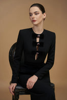 Black crepe de chine and velvet gown by I.H.F featuring a V-neck, long sleeves, and elegant column silhouette.