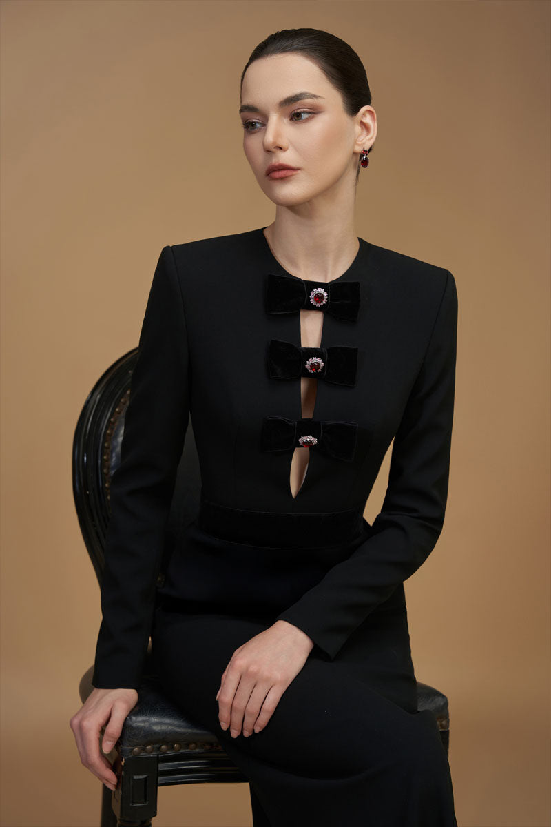 Black crepe de chine and velvet gown by I.H.F featuring a V-neck, long sleeves, and elegant column silhouette.