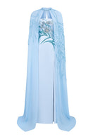 Blue chiffon gown with elegant cape by Tracy Studio, featuring flowing fabric and sophisticated design for formal occasions.