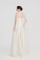 Elegant taffeta gown with cape by Tracy Studio, featuring a flowing silhouette and intricate detailing in a sophisticated design.