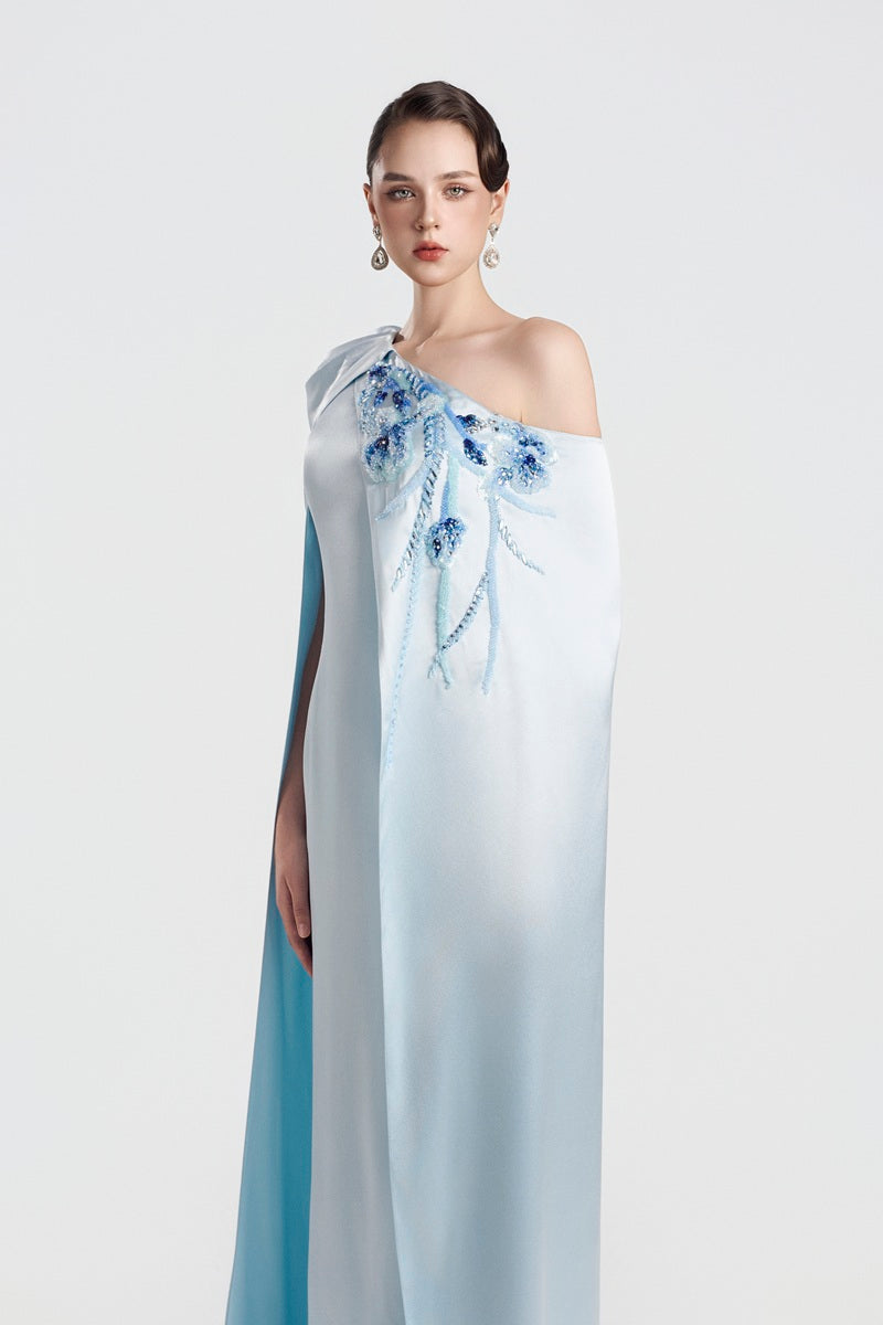 Blue asymmetrical taffeta maxi dress by Tracy Studio featuring elegant draping and a flowing silhouette.