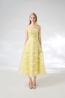 Light yellow strapless gown from HAPPY CLOTHING with floral necklace, elegant and flowing for formal occasions.