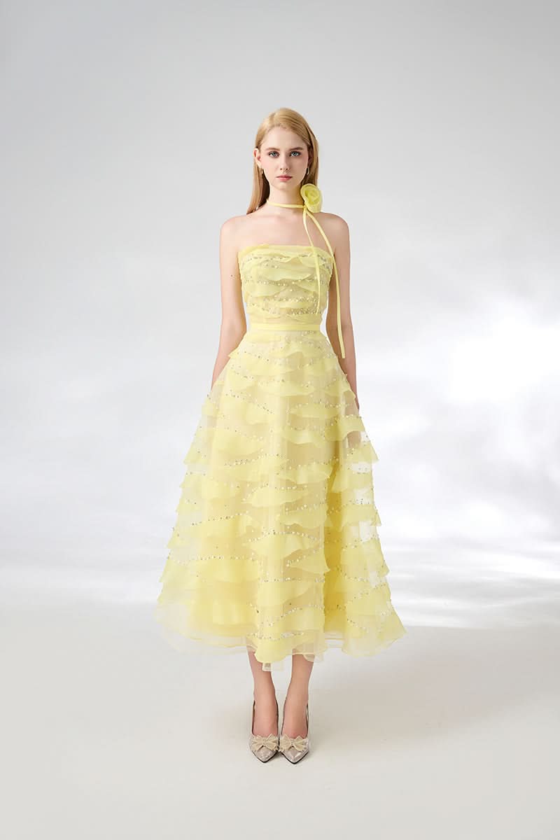 Light yellow strapless gown from HAPPY CLOTHING with floral necklace, elegant and flowing for formal occasions.