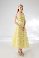 Light yellow strapless gown from Happy Clothing with a floral necklace, featuring a flowing design and elegant style.