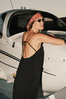 DUMA&CO Resonancia Maxi Dress in flowing fabric with a vibrant pattern, displayed on a hanger against a neutral background.