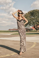 DUMA&CO Piedra Dress maxi dress in flowing fabric with a fitted waist and elegant neckline, displayed on a hanger.
