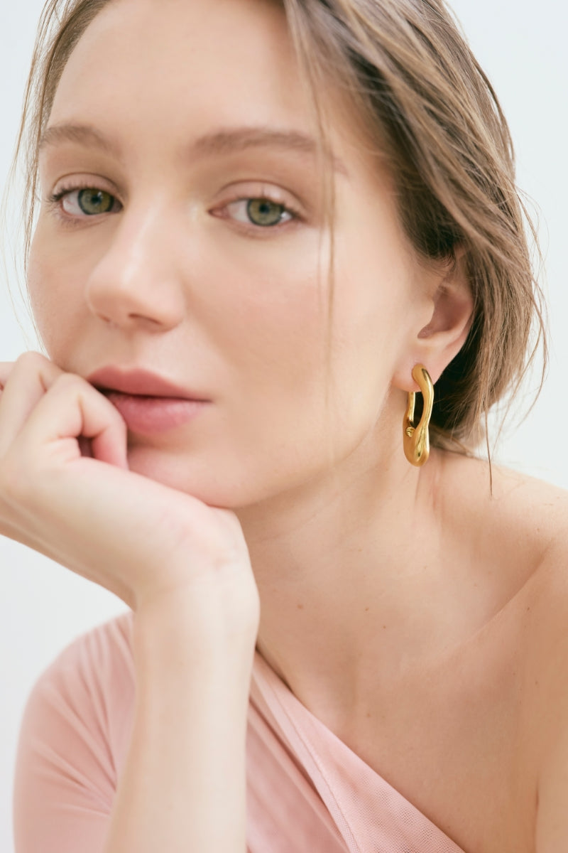 Gold VOLAR hoop earrings by Eugenia Ospina featuring sleek, minimalist circular design for a stylish accessory.
