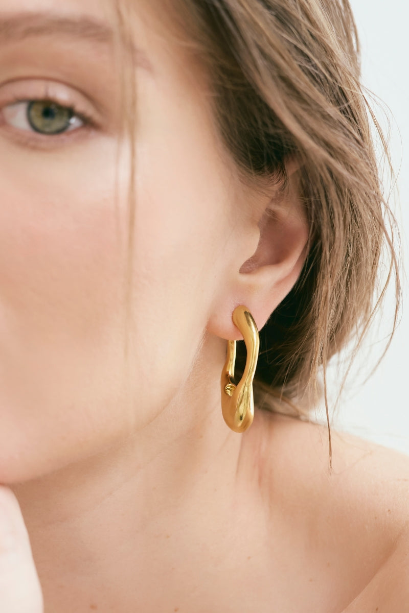 Gold VOLAR hoop earrings by Eugenia Ospina featuring sleek, minimalist hoop designs with a polished finish.