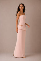 Light pink Vera gown by Nihan Peker, flowing fabric and elegant design, shown hanging on a wooden hanger.