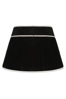 Black Victoria velvet mini skirt by Nana Jacqueline shown from the back, highlighting its sleek fit and plush velvet fabric.