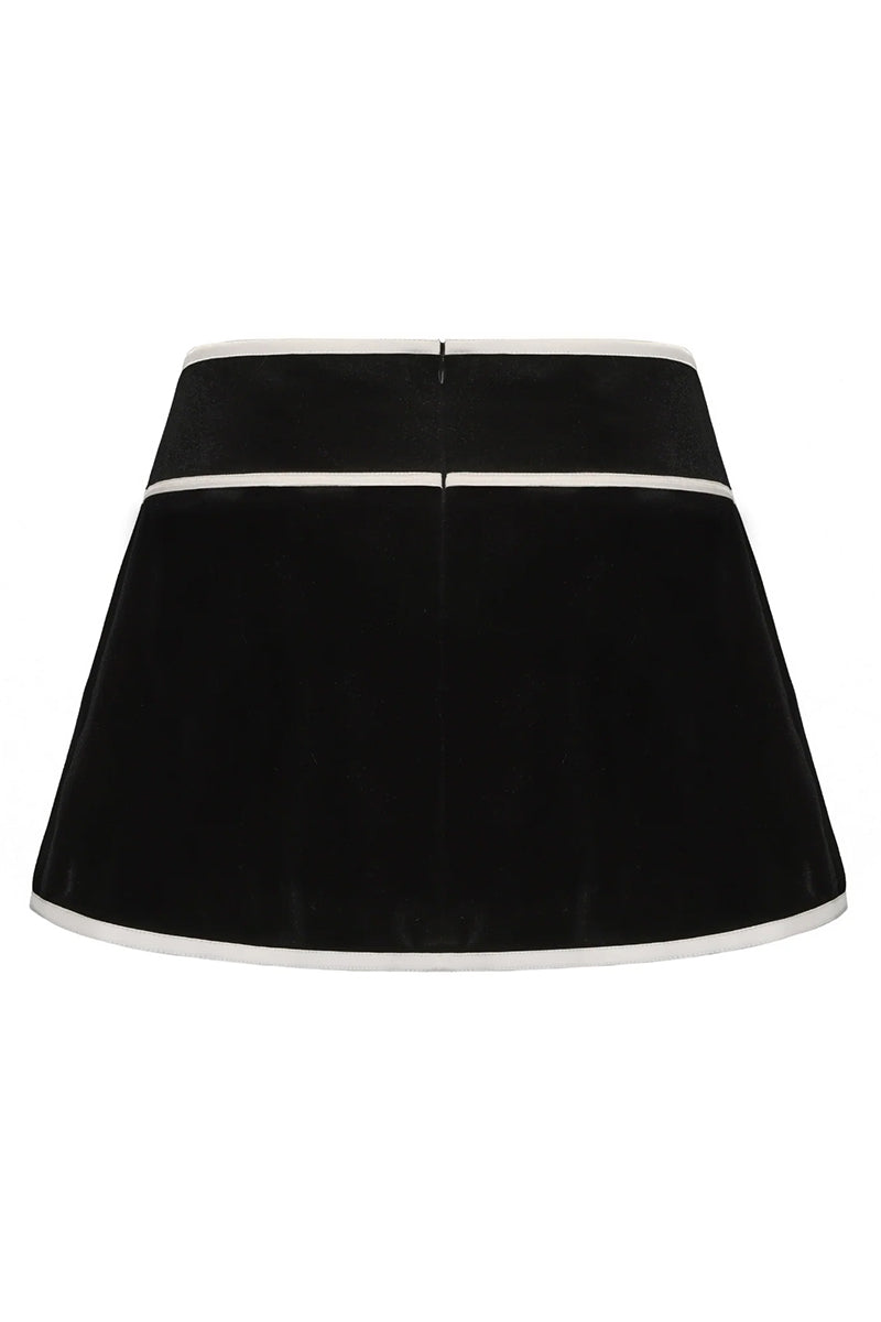Black Victoria velvet mini skirt by Nana Jacqueline shown from the back, highlighting its sleek fit and plush velvet fabric.