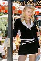 Black Victoria velvet mini skirt by Nana Jacqueline, shown in a stylish fashion campaign image.