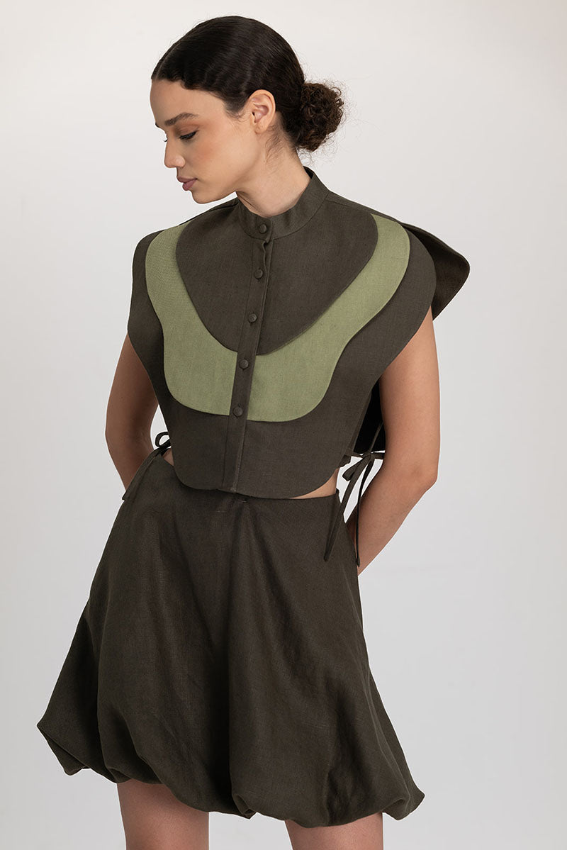 VIVRA bib top in lichen green and sage green by ANA + MARIA, featuring a stylish sleeveless design and soft fabric.