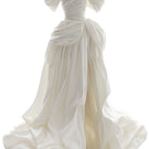Elegant off-white Venera Blanche gown by Monetre displayed on a hanger with flowing fabric and detailed design.
