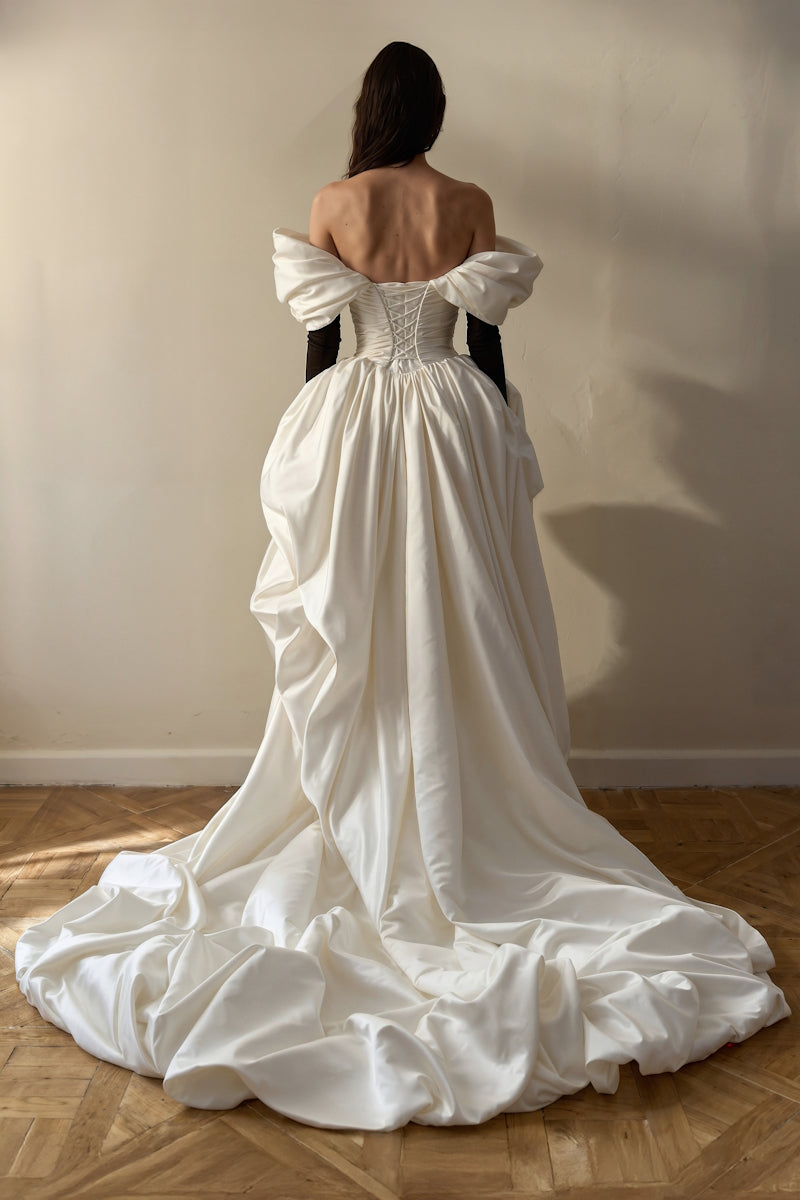 Elegant Venera Blanche gown by Monetre in off-white fabric, featuring flowing design and intricate details.