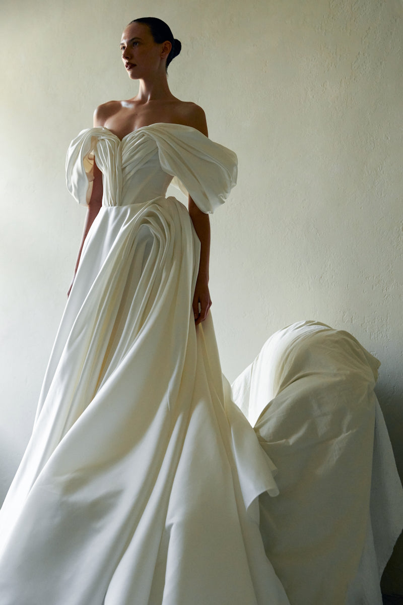 Elegant Monetre Grace Gown in flowing fabric with intricate embroidery, displayed on a mannequin.