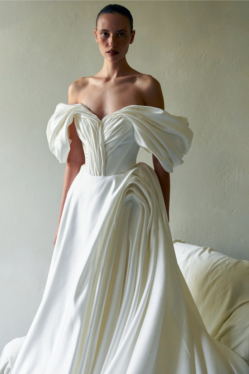 Elegant Monetre Grace gown in flowing fabric, featuring intricate details and a graceful silhouette on a neutral background.