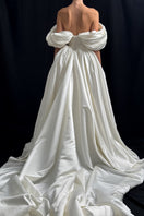 Off-white Monetre Grace gown displayed on a hanger, featuring elegant fabric and detailed design for formal occasions.