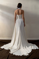 Off-white Luna gown by Monetre featuring elegant fabric and flowing design, perfect for formal occasions.