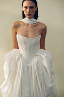 Elegant VESNA gown by Monetre featuring flowing fabric and intricate detailing, displayed on a neutral background.