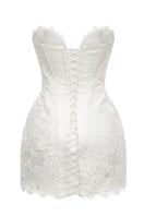 Off-white Serena Nuance gown by Monetre featuring elegant fabric and intricate design, displayed on a hanger.