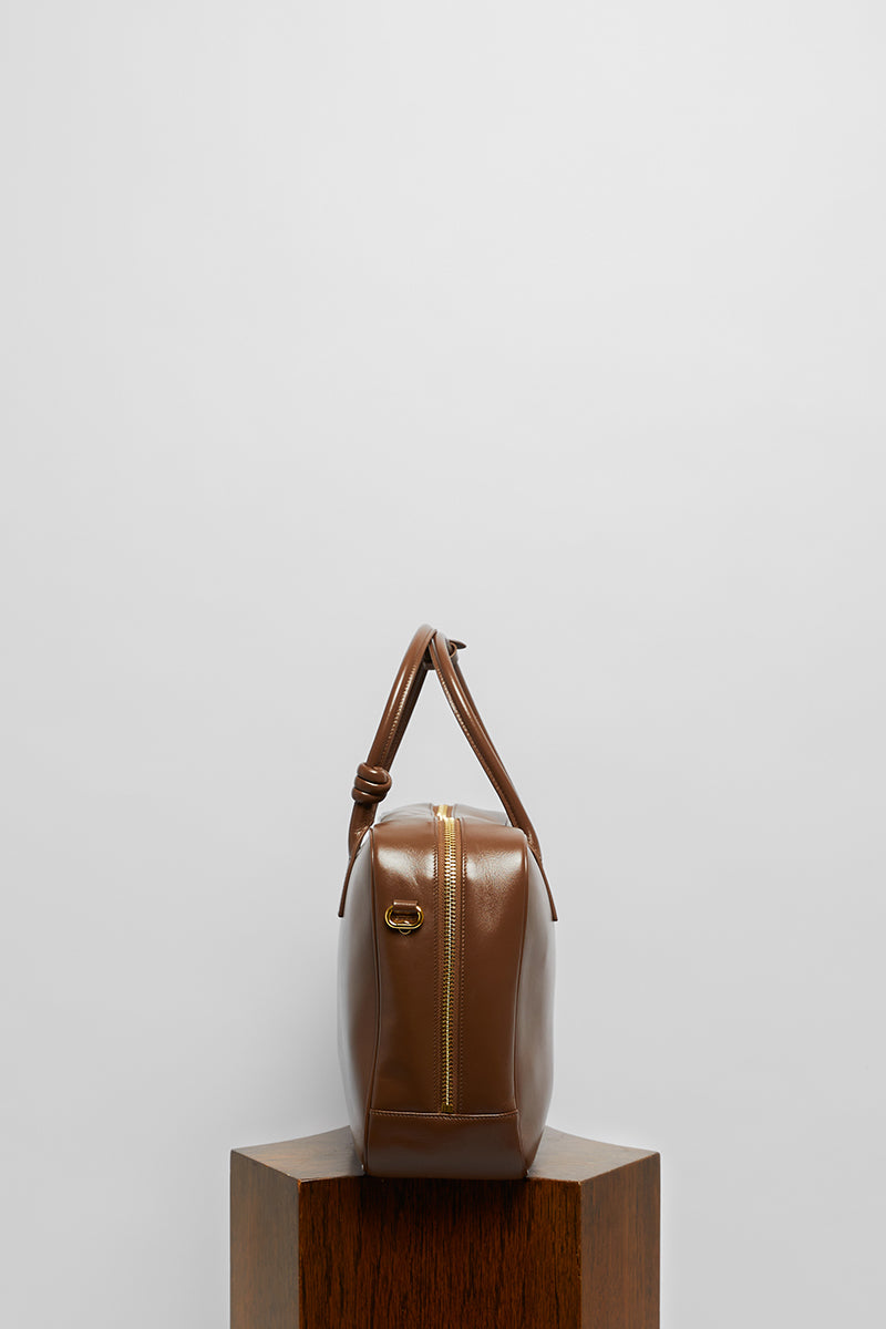 Leather work bag in mocha color with top handle, crafted by Folklore The Label, showcasing durable leather and elegant design.
