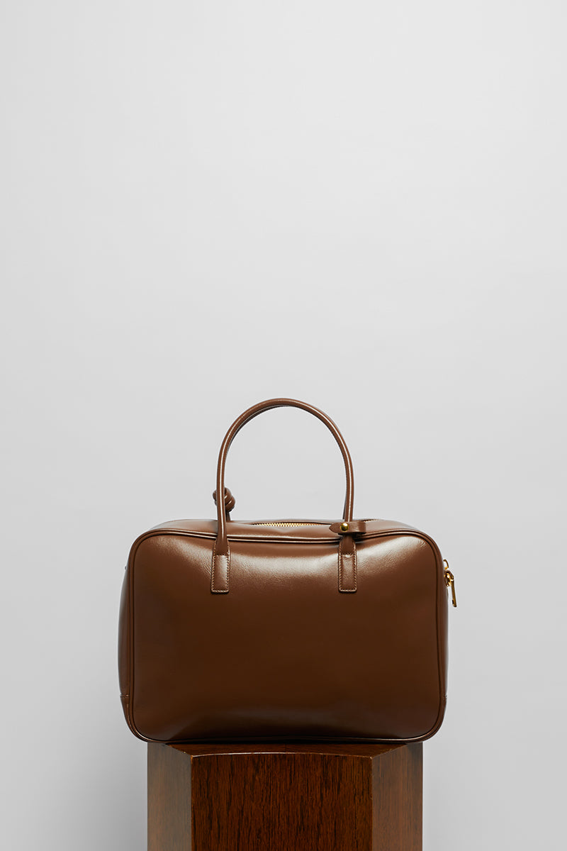 Leather work bag in mocha color with top handle, from Folklore The Label, featuring a spacious design and elegant stitching.