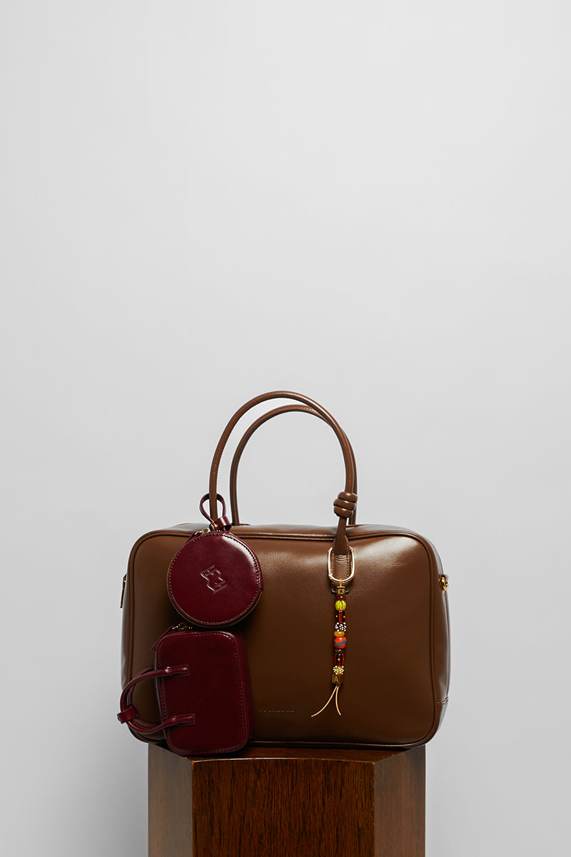 Leather work bag in mocha with top handle from Folklore The Label, featuring a sleek, stylish design and durable leather material.
