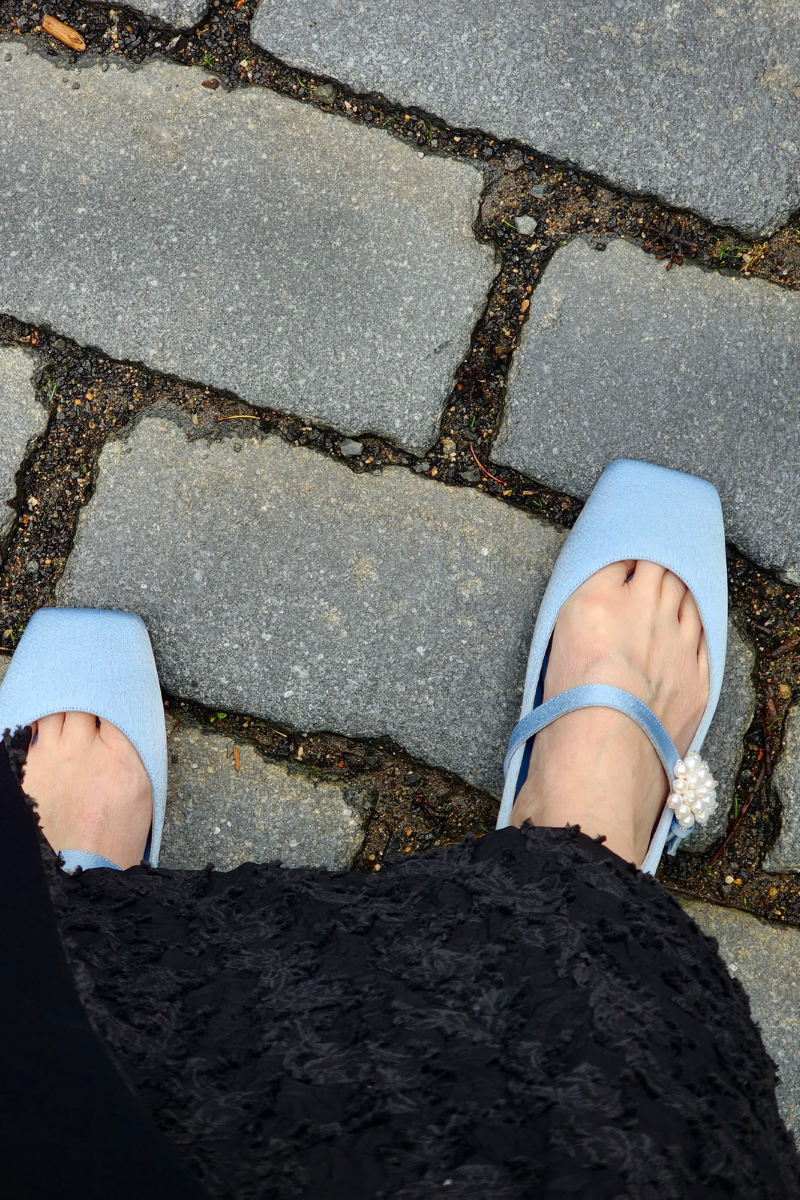 Christin Wu WILLA flats in bluebell color, shown being worn on a model's feet in a casual lifestyle setting.