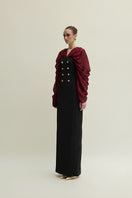Elegant Jenny K Tran Willow gown in burgundy and black displayed on a dress form. Flowing fabric and detailed design visible.