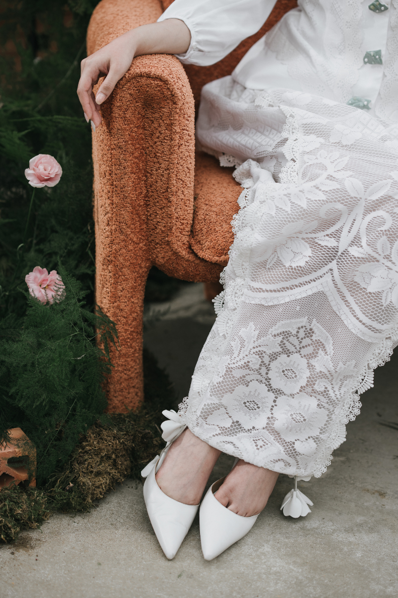 Christin Wu Willow Heels featuring elegant jasmine-inspired design, shown on a model in a lifestyle setting.